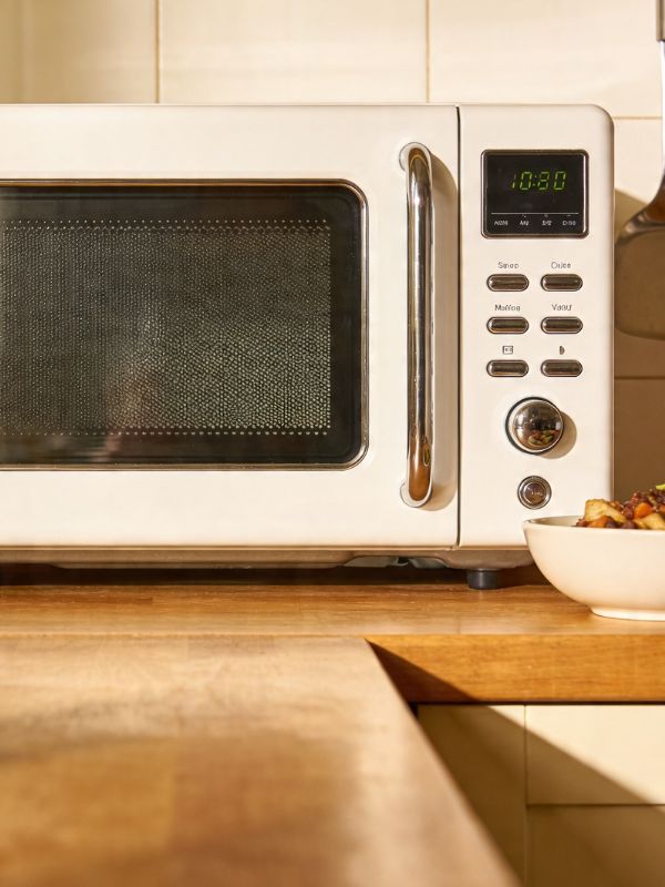 Appliance repair technician servicing an over-the-range microwave for no-heat and magnetron problems in a Lubbock, TX kitchen